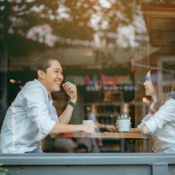 Two people sitting at a table in a cafe.