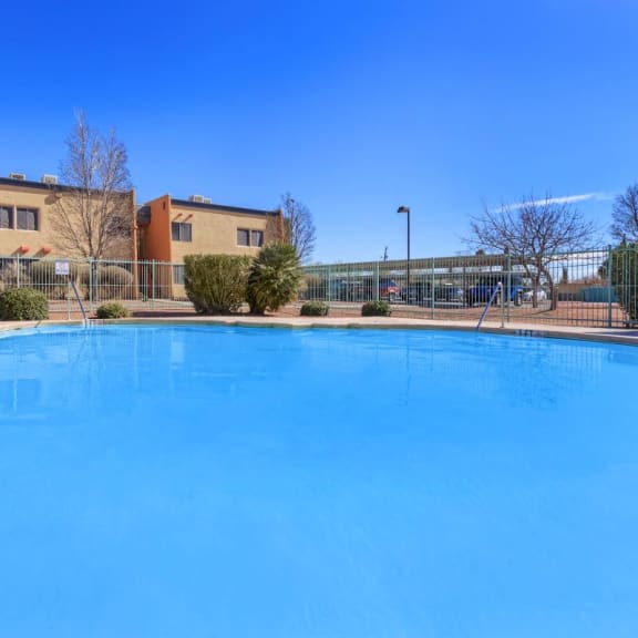 a large swimming pool with a building in the background