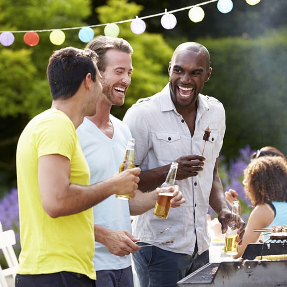 a group of men and women at a backyard barbecue
