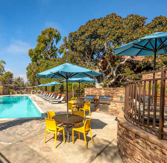 a swimming pool with chairs and umbrellas at a resort