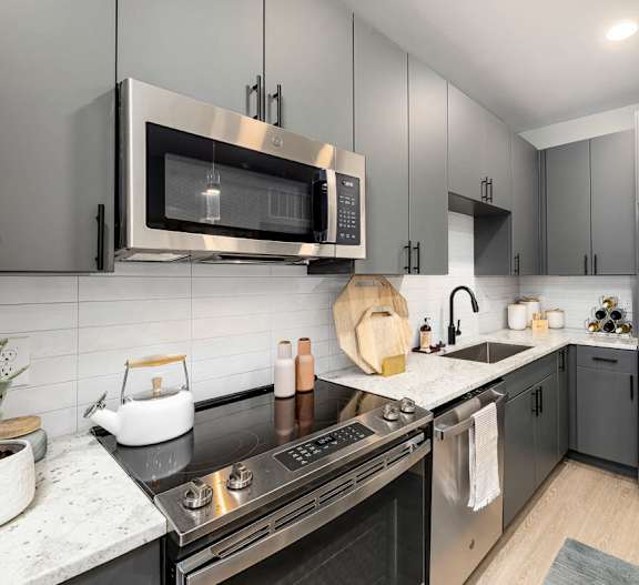 a modern kitchen with stainless steel appliances and black counter tops