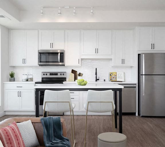 a kitchen with white cabinets and a stainless steel refrigerator