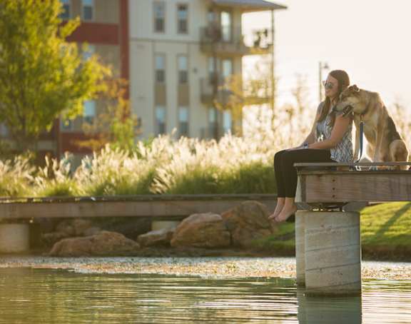 Woman Sitting with Dog at Discovery at The Realm, Texas