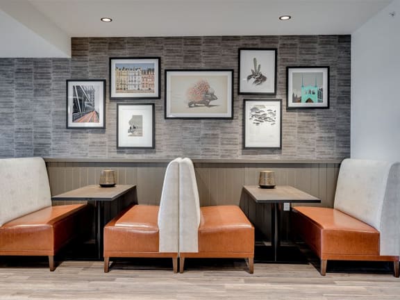 a seating area with chairs and pictures on the wall