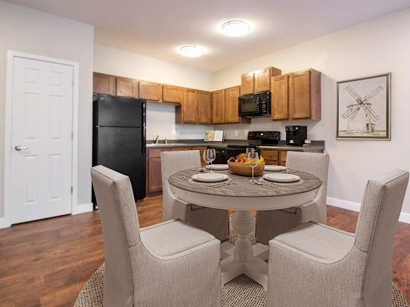 A kitchen with a table and chairs in the middle of the room.