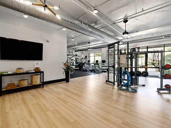 A modern living room with a large abstract painting on the wall and a wooden floor.