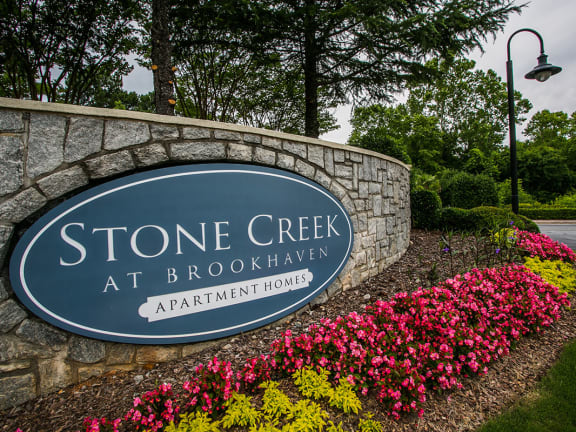 a sign for stone creek at brookhaven apartments