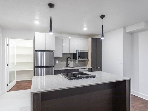 a kitchen with an island and a refrigerator and a sink