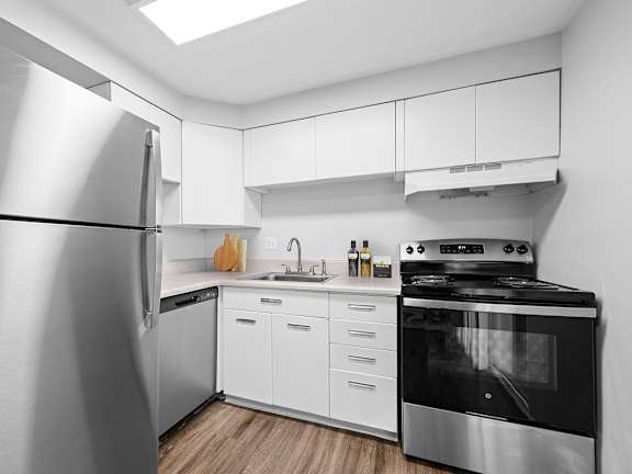 A kitchen with a black oven and microwave built into the cabinetry.