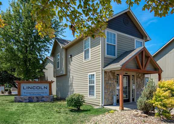 A house with a sign that says Lincoln Townhomes in front of it.