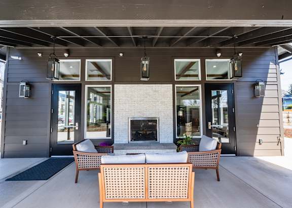 A patio with a fireplace and chairs.