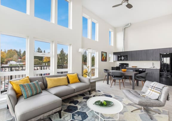 a living room with a gray couch and yellow pillows at Sedona Apartments in Seattle, WA