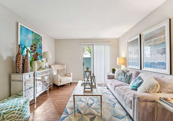 A living room with a couch, chair, and a painting on the wall.