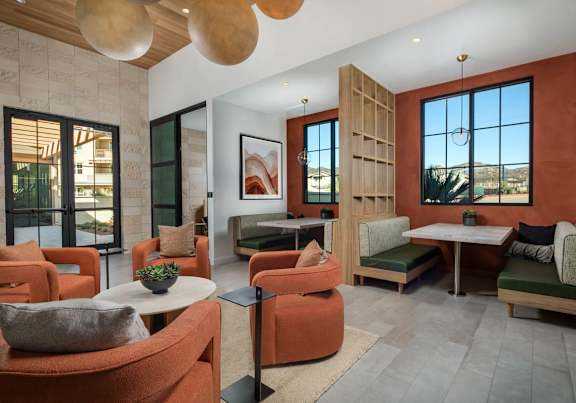 A modern living room with orange chairs and a white table.
