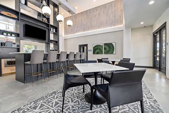 A modern dining room with a large table and chairs.