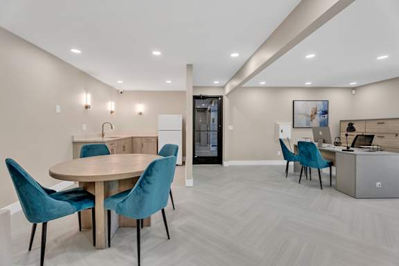 A modern dining room with a round table and blue chairs.