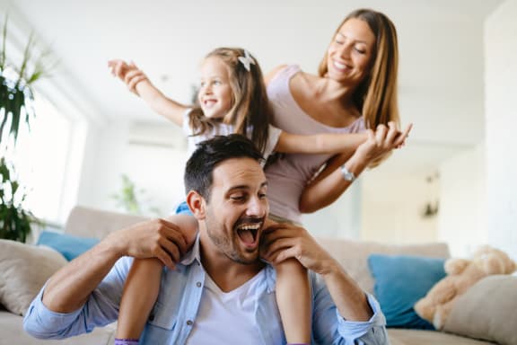 a man and woman sitting on a couch with their daughters