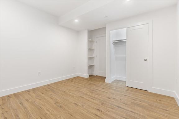 A room with a white door and a white fridge.