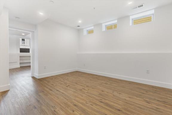 A room with wooden flooring and white walls.