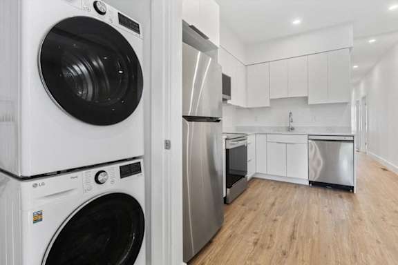 A modern kitchen with a washing machine and a refrigerator.