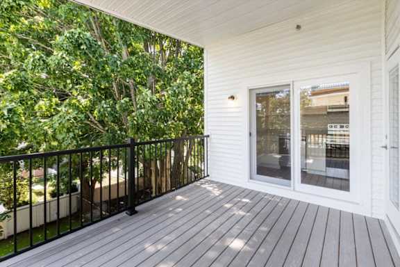 A balcony with a black railing and a glass door.