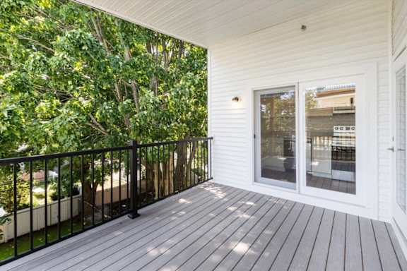 A balcony with a black railing and a glass door.