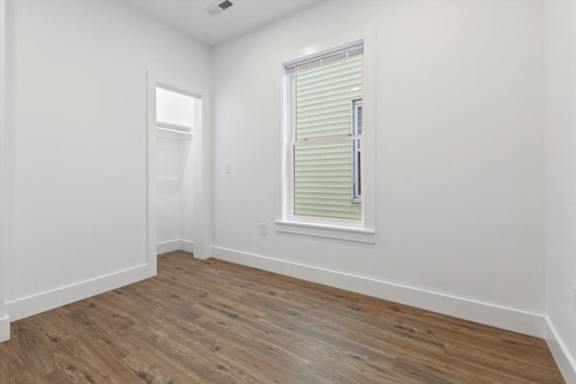 A room with a window and wooden flooring.