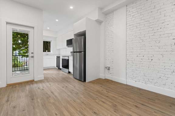 A kitchen with a refrigerator, oven, and microwave.