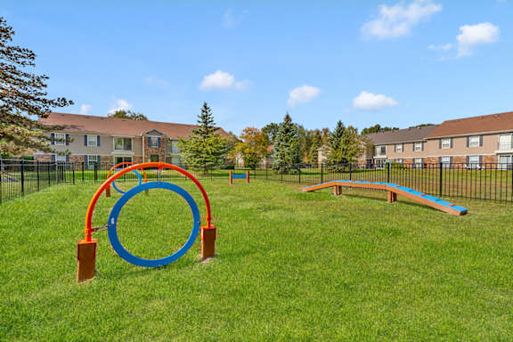 A playground with a blue and orange ring structure and a blue and orange slide.