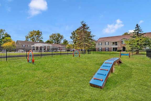 A playground with a blue seesaw and orange rings.