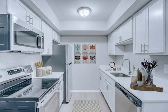 A modern kitchen with white cabinets and stainless steel appliances.