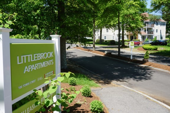 a green sign apartments on the side of a street at Littlebrook Apartments, Hudson