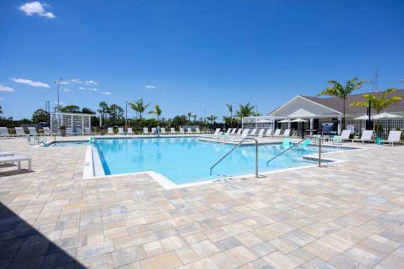 A large outdoor swimming pool surrounded by sun loungers.