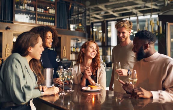 a group of people sitting at a table at a bar