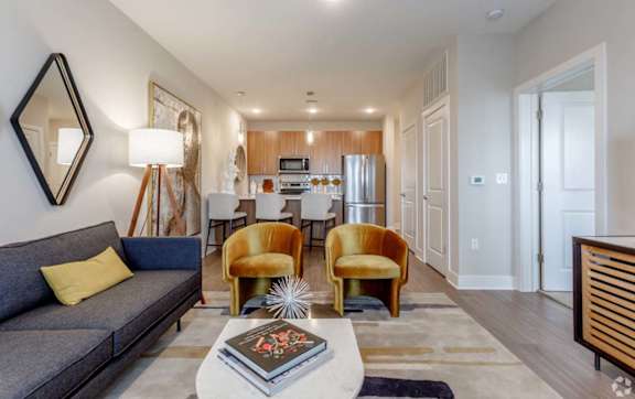A modern living room with a grey sofa, yellow chairs, and a coffee table.