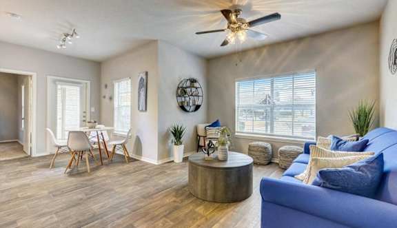 a living room with a blue couch and a ceiling fan