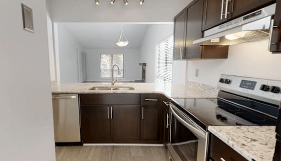 A kitchen with dark brown cabinets and a white stove top oven.
