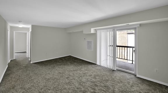 an empty living room with a door to a balcony