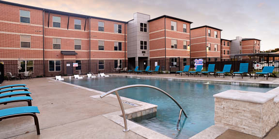 an image of a city with a pool and buildings with orange lights at The Liberty Lofts, Gainesville