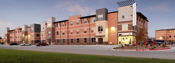 a view of a building on a city street at dusk at The Liberty Lofts, Gainesville, TX, 76240