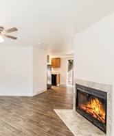 A living room with a fireplace and a ceiling fan.