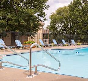 Steps leading into the outdoor pool with surrounding seating and a clean, inviting deck.