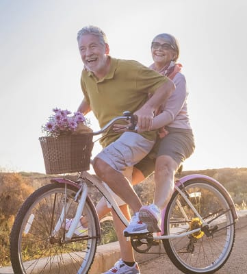 Lifestyle photo of older couple riding a bike together