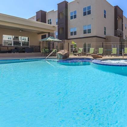 a large swimming pool with an apartment building in the background
