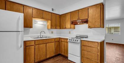 a kitchen with white appliances and wooden cabinets