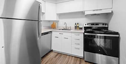 A modern kitchen with a stainless steel refrigerator and oven.
