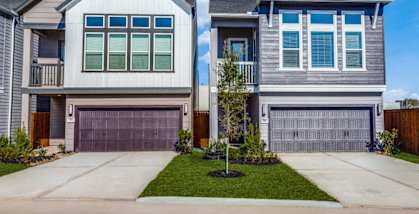 Two houses with garages and driveways in front.