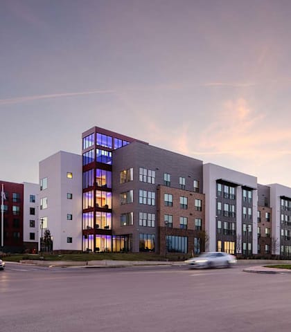 A modern building with a parking lot in front of it.