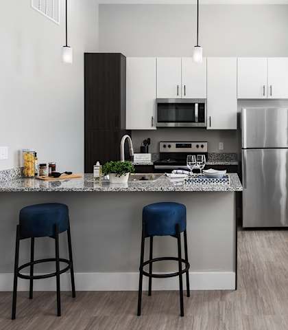 kitchen and dining area at the district flats apartments in lenexa at The Residences at Delmar DivINe, Missouri, 63112