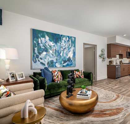 A living room with a green couch and a large painting on the wall at Citron Anaheim, CA 92805